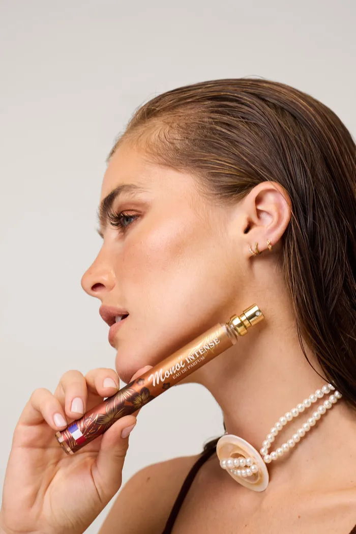 Femme montrant le parfum 35ML, Monoï intense de notre gamme Collection Platinium