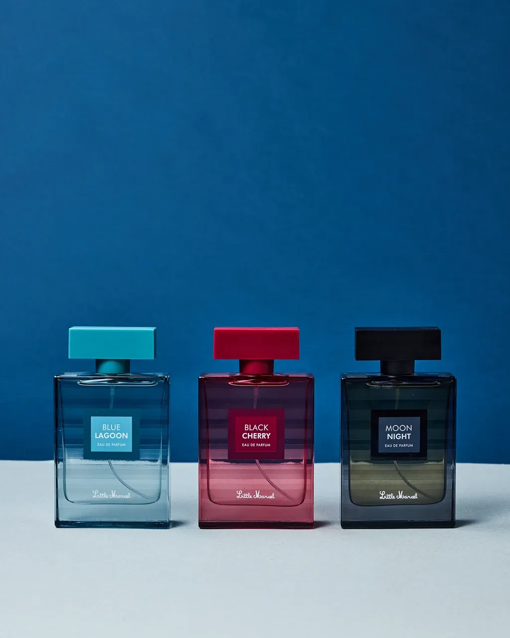 Flacon de parfum transparent sur un fond bleu et jaune symétrique 