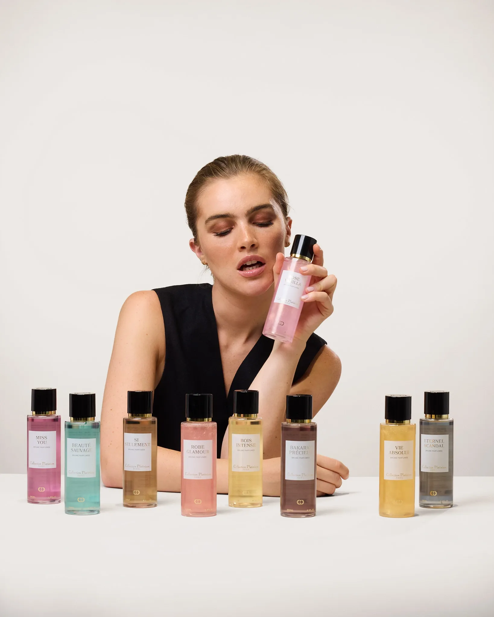 Femme présentant divers parfums de notre gamme Collection Platinium