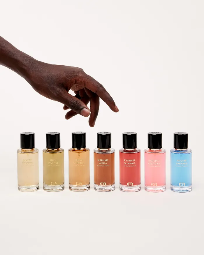 Main tendue au dessus de divers parfums de notre marque Collection Platinium très colorés